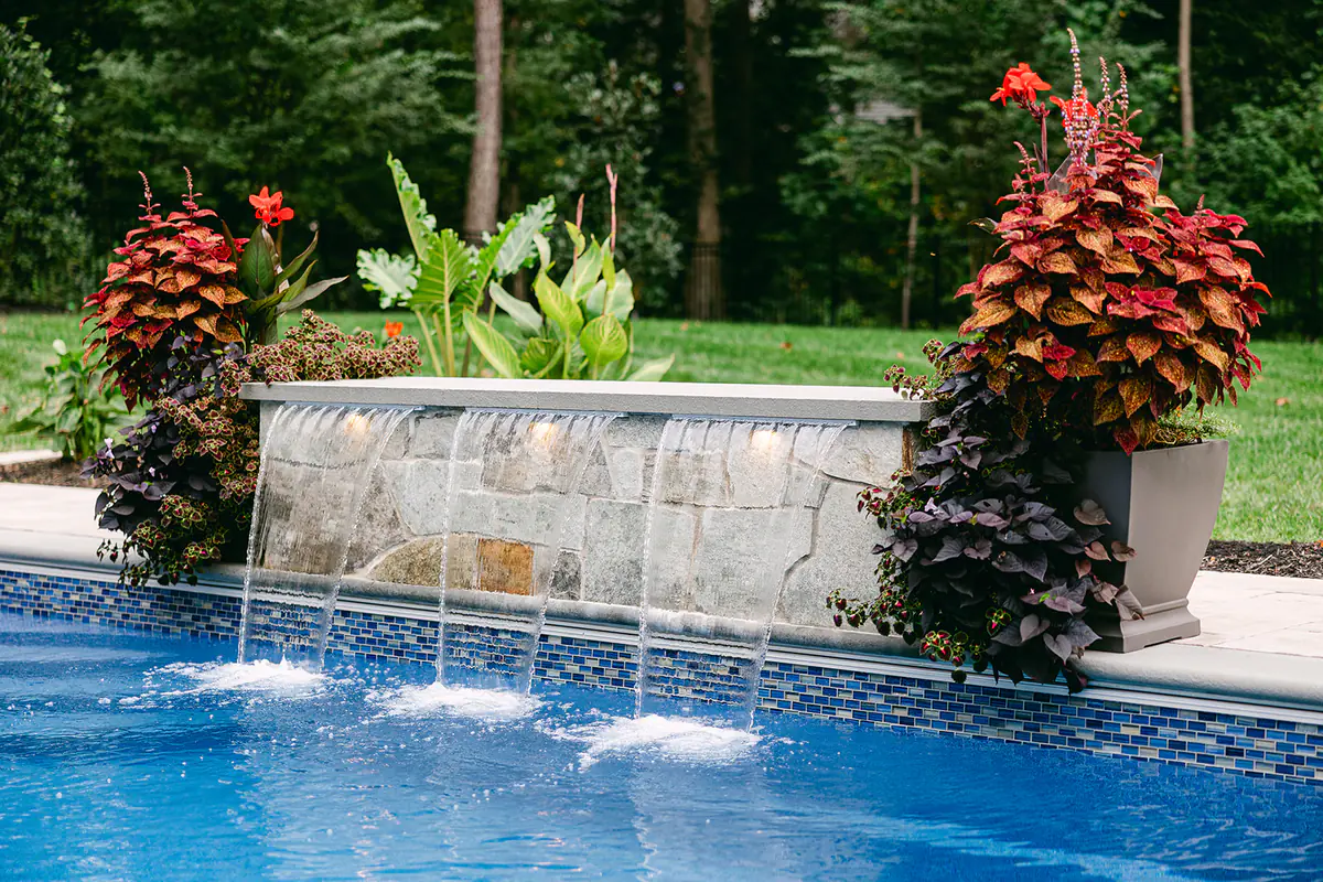 water feature by pool and greenery