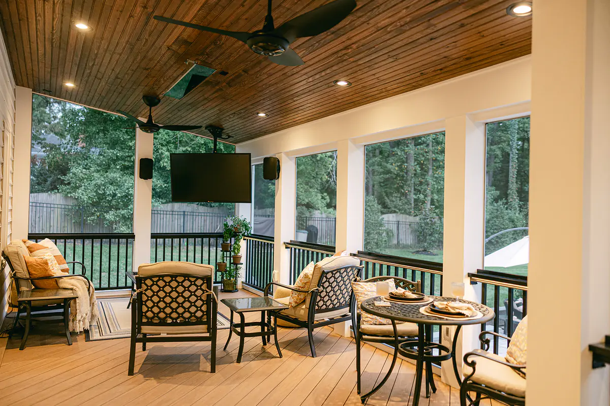 cozy deck space with warm lighting, furniture and tv