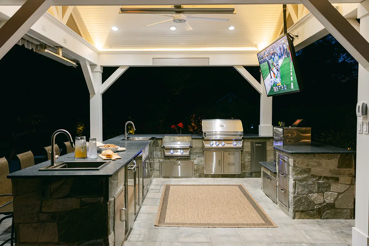 pavilion at night with outdoor tv and kitchen