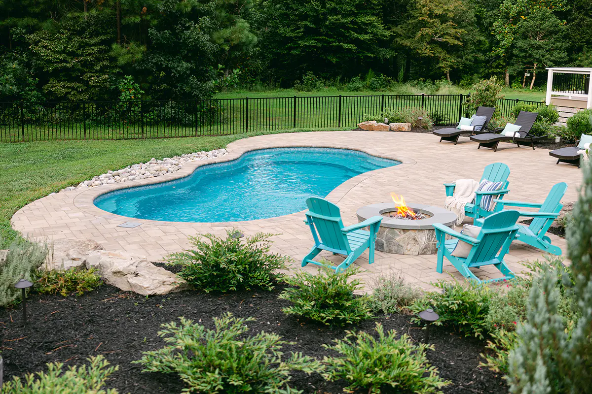 custom outdoor poolscape with landscaping and firepit