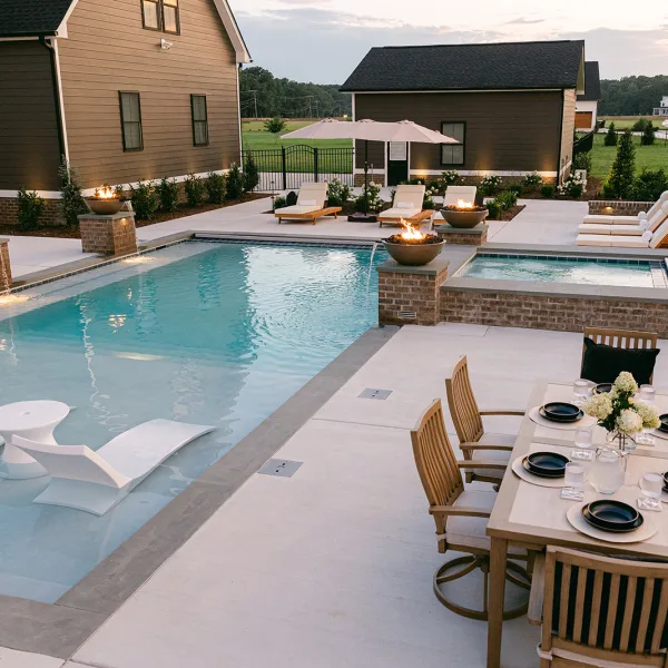 Fiberglass pool with integrated fire bowl fountains and expansive tanning ledge