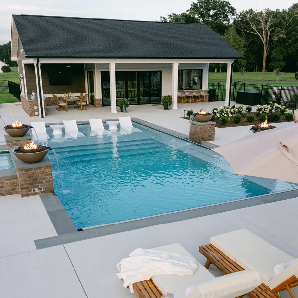 	Modern inground pool with wrap-around bench, tanning ledge, and dual entry