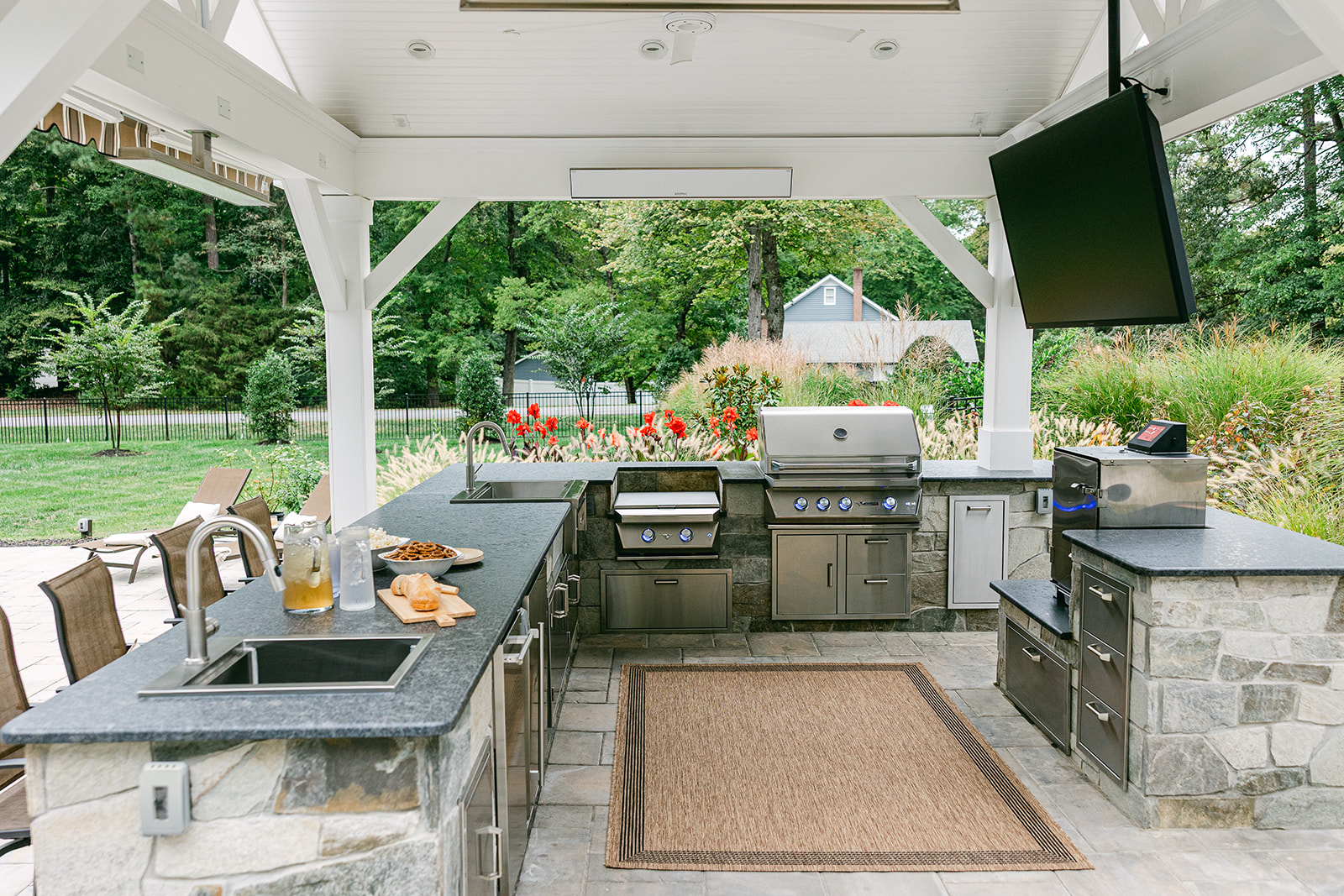 outdoor kitchen under pavilion with outdoor tv