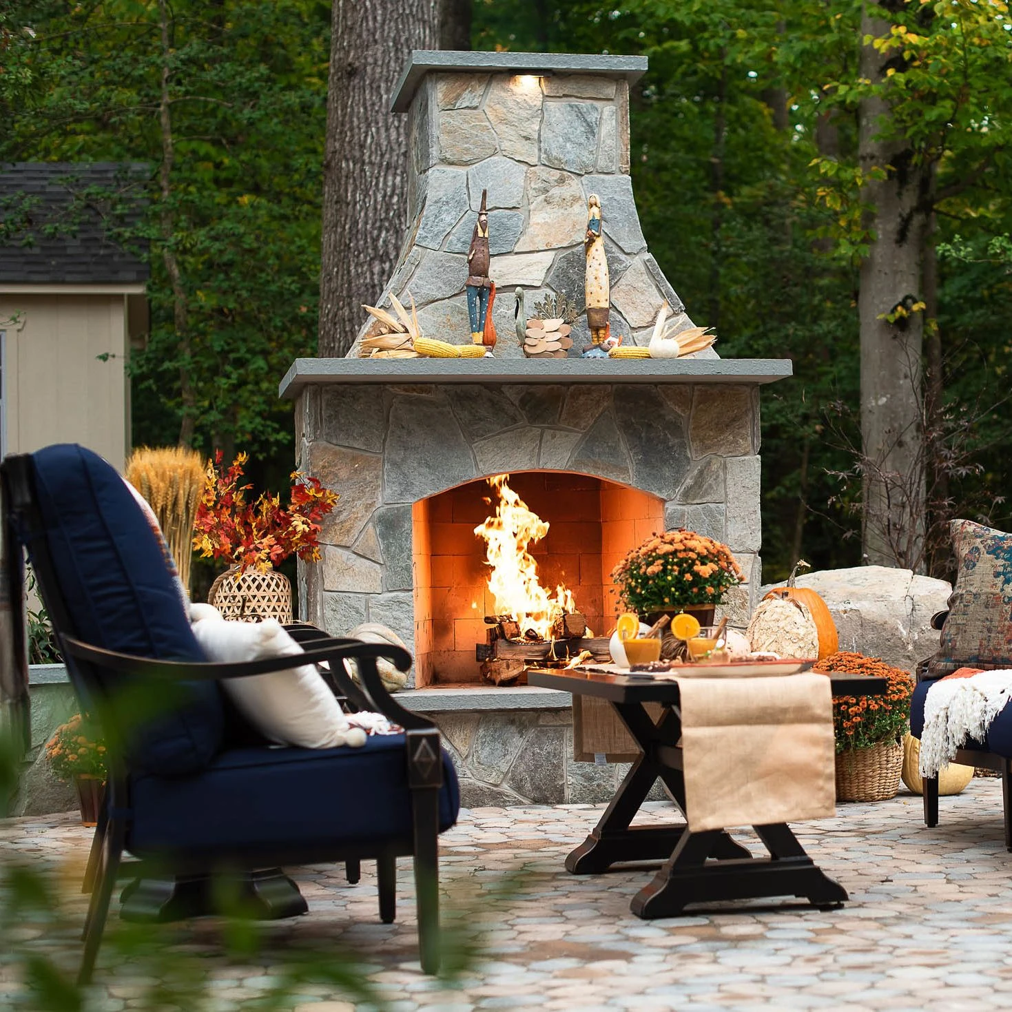 Beautiful sone outdoor fireplace with large mantle decorated for the fall