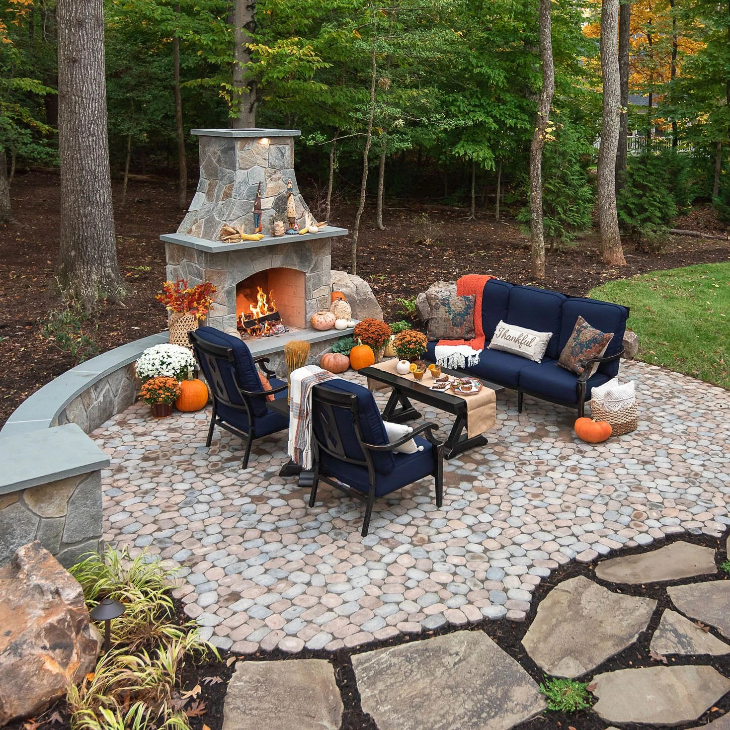 Cozy outdoor seating by the large stone fireplace