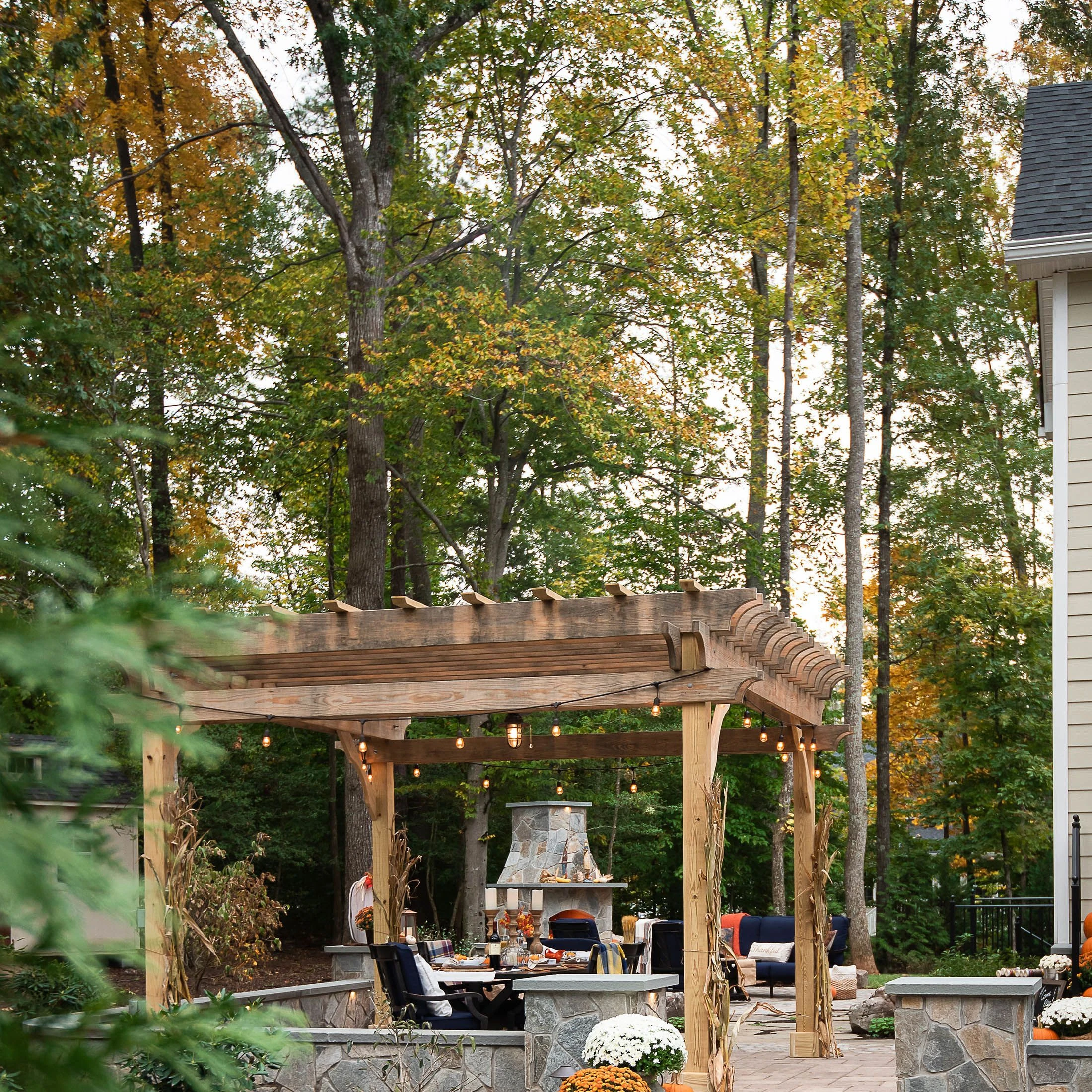 Rustic dark stain pergola on paver patio covering sitting area of large backyard space