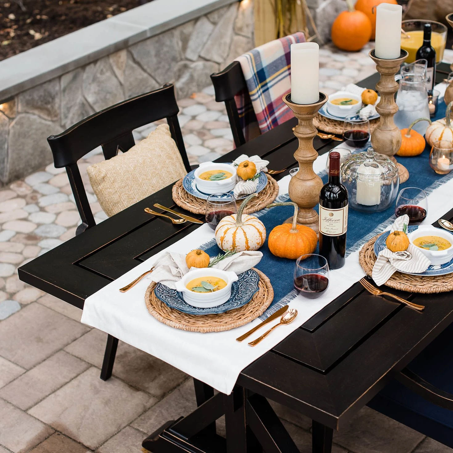 Stone sitting wall and paver patio furnished with dining furniture