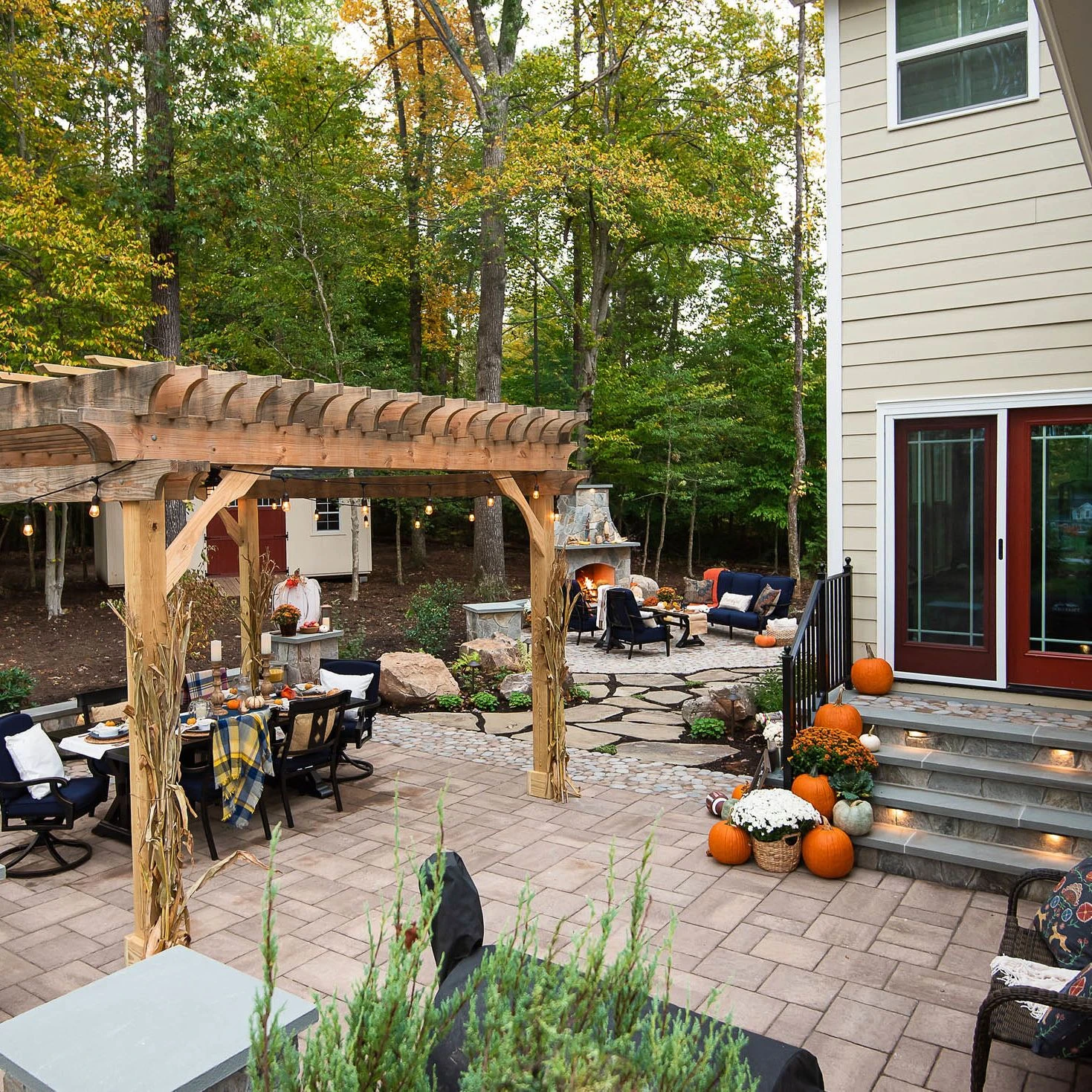 wrap around patio featuring pergola and large stone fire place