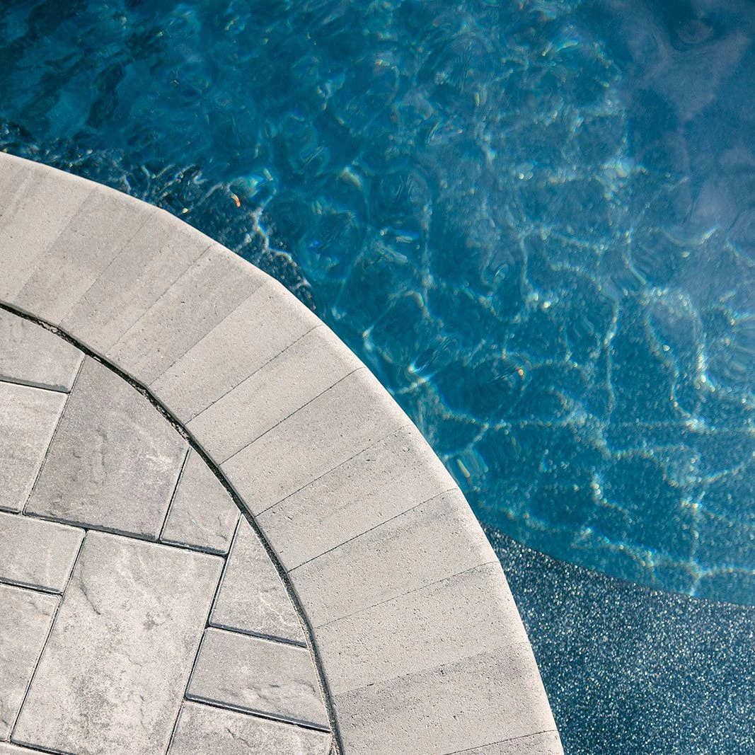 Limestone Fullnose coping and caps surrounding tiered pool deck