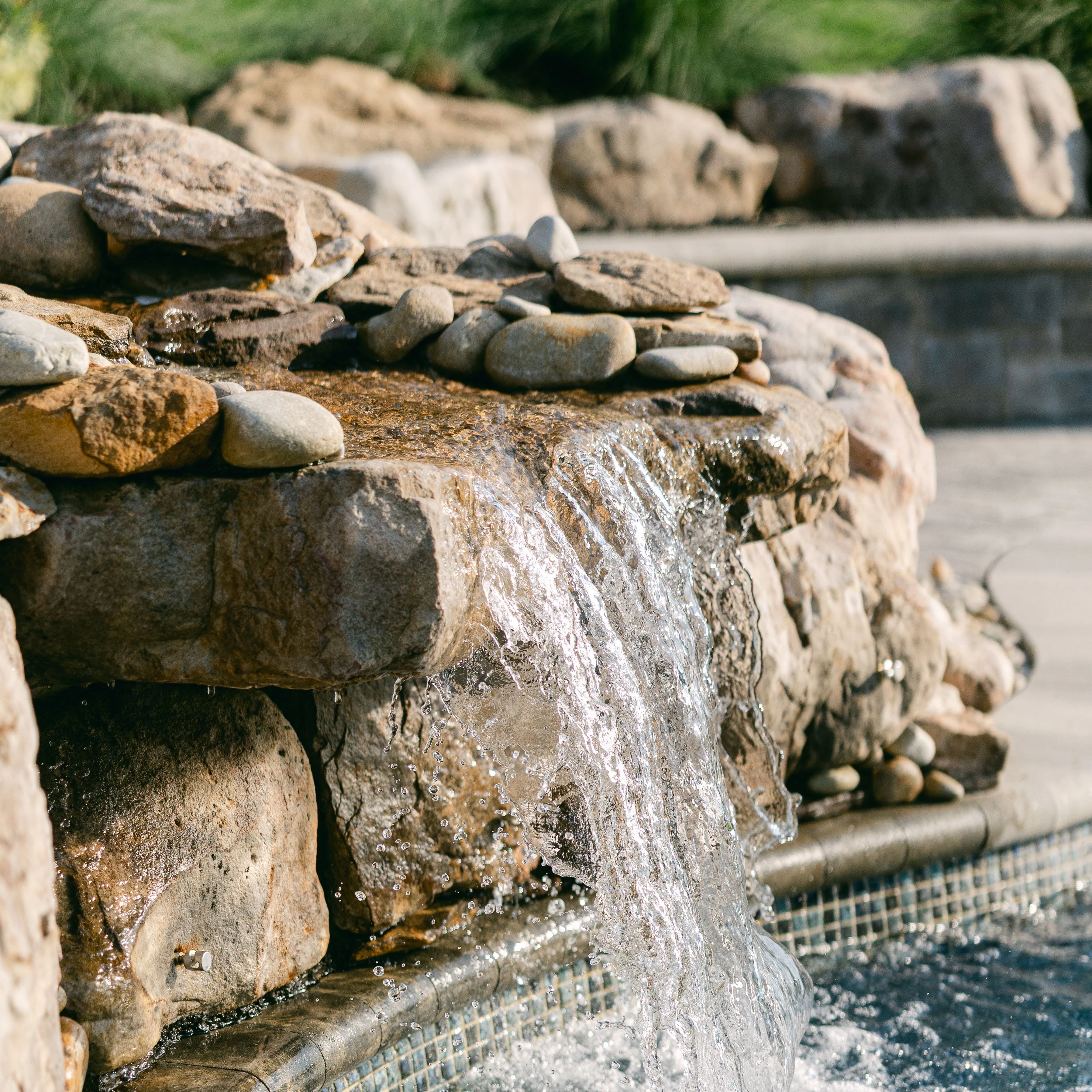 	Stream water feature with natural stone leading into freeform pool