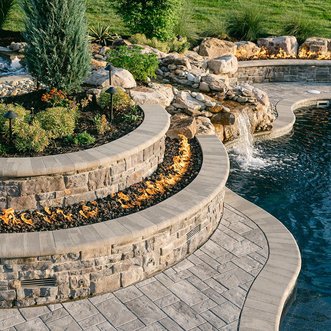 Tiered poolside decking with Steel Mountain Treo pavers and Fullnose edging