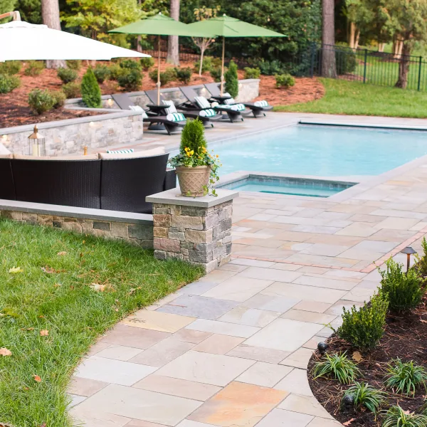 Stone path leading to a backyard pool with retaining wall features