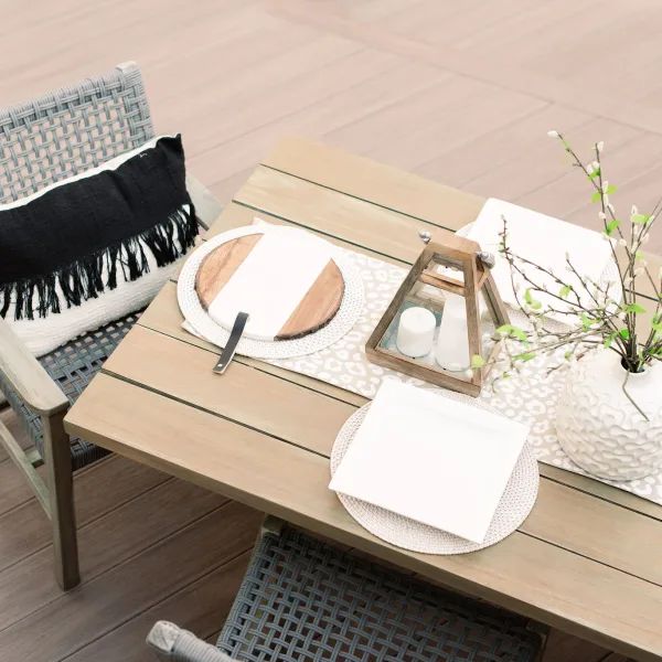 Composite deck furnished with wooden table and wicker chairs