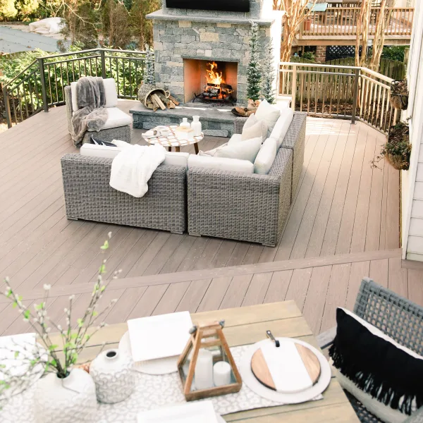 two tiered composite back deck with stone fireplace and furniture