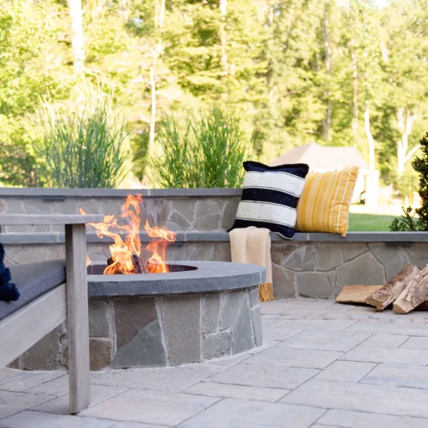 Stone, wood burning fire pit with bench-style sitting wall