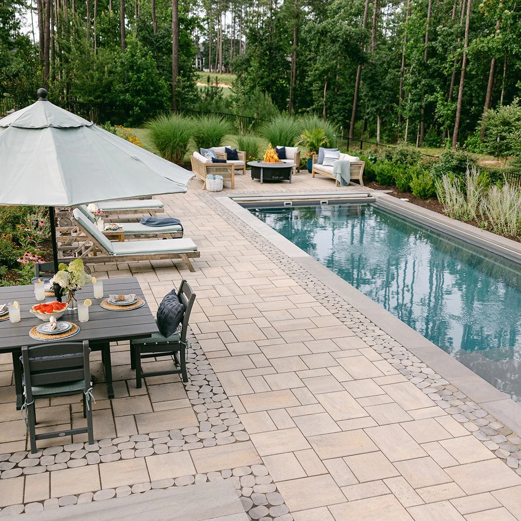 Garden-inspired poolscape with stone deck and custom grill island
