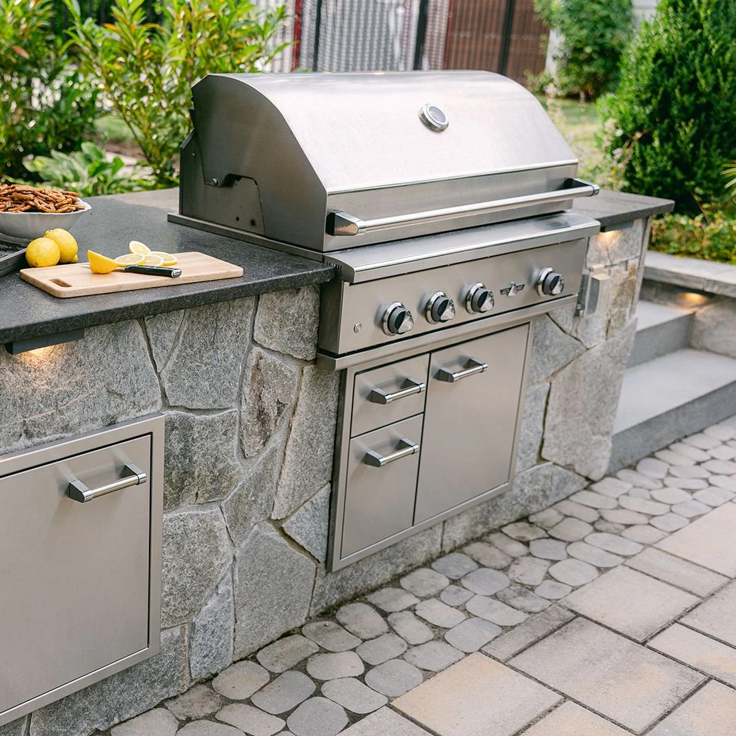 	Garden-inspired poolscape with stone deck and custom grill island