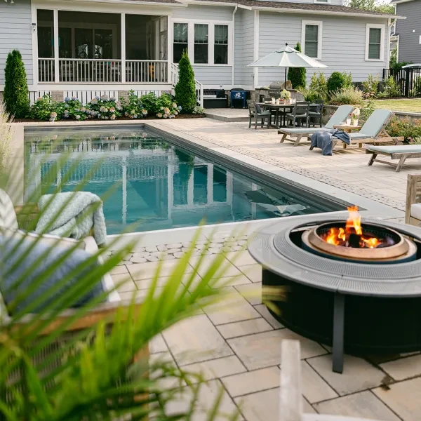 Modern fire pit beside fiberglass pool