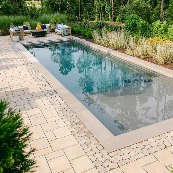 Rectangular backyard pool with safety cover and soft garden backdrop