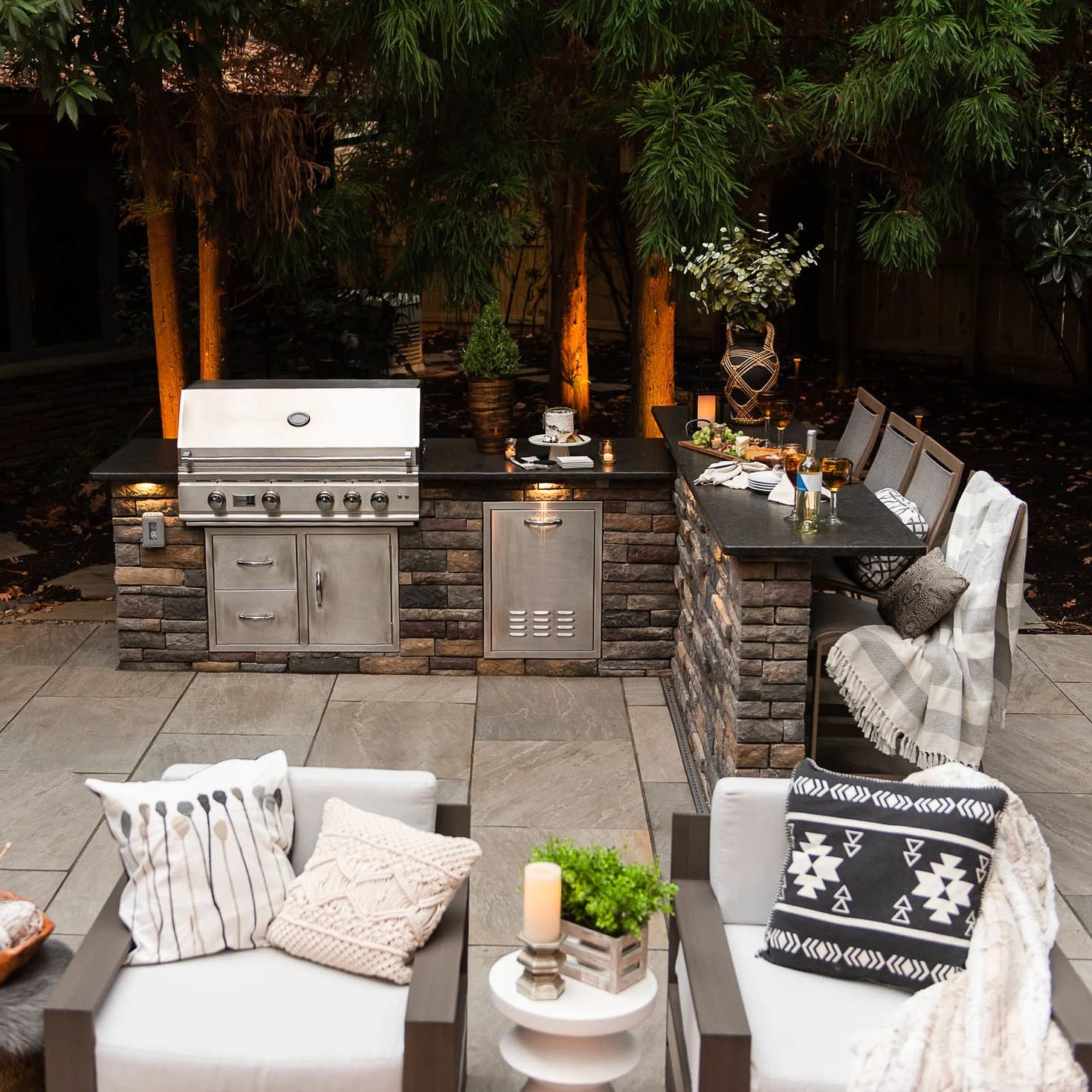 Outdoor grill island with bar seating and granite countertop