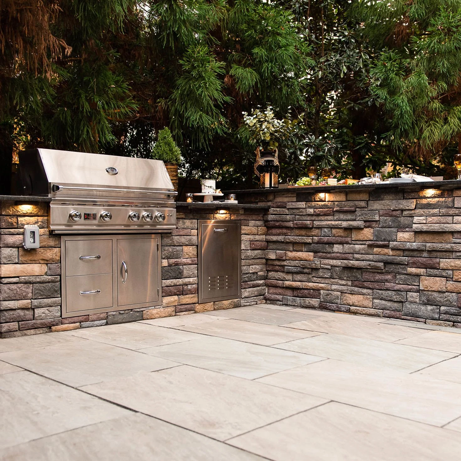 Stainless Steal gas grill installed into a stacked veneer outdoor island
