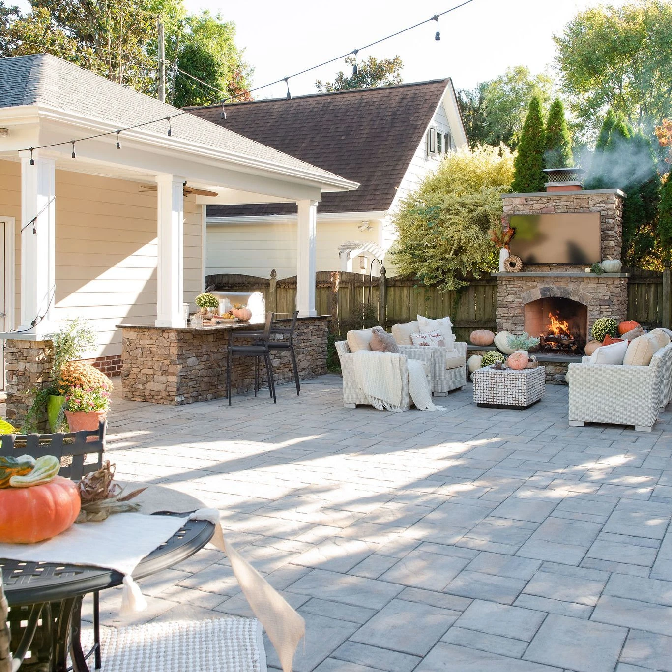 Outdoor fireplace with stone surround on paver patio