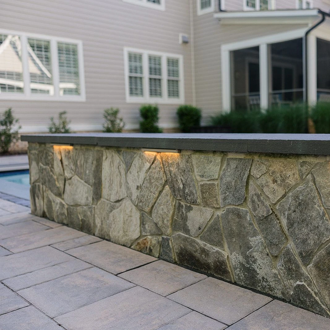 Brick-accented patio design with slope-adapted landings and rich stone textures