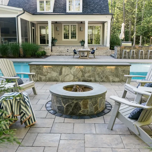 Stone fire pit feature integrated into backyard hardscape