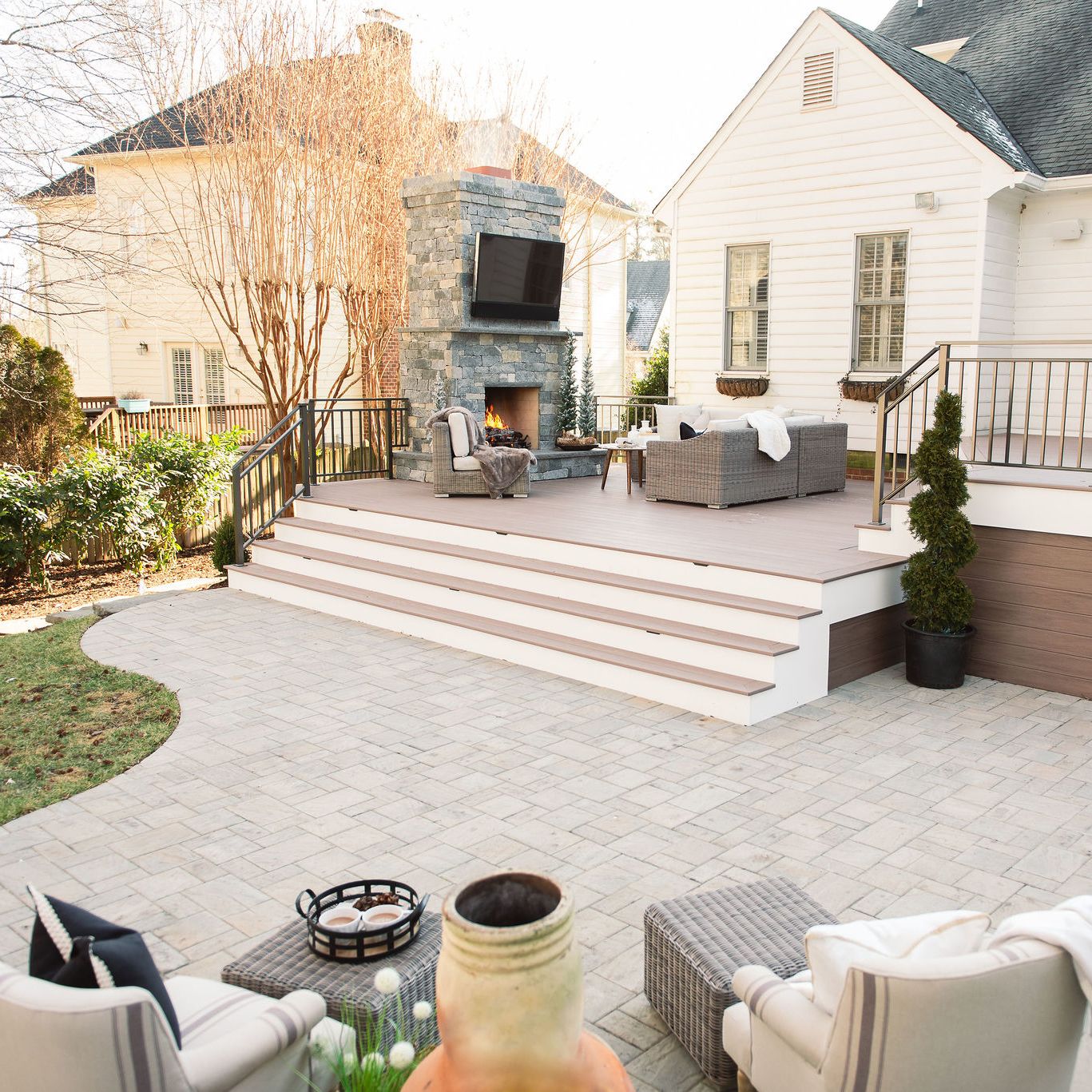 huge custom backyard with a fire place on the deck and patio