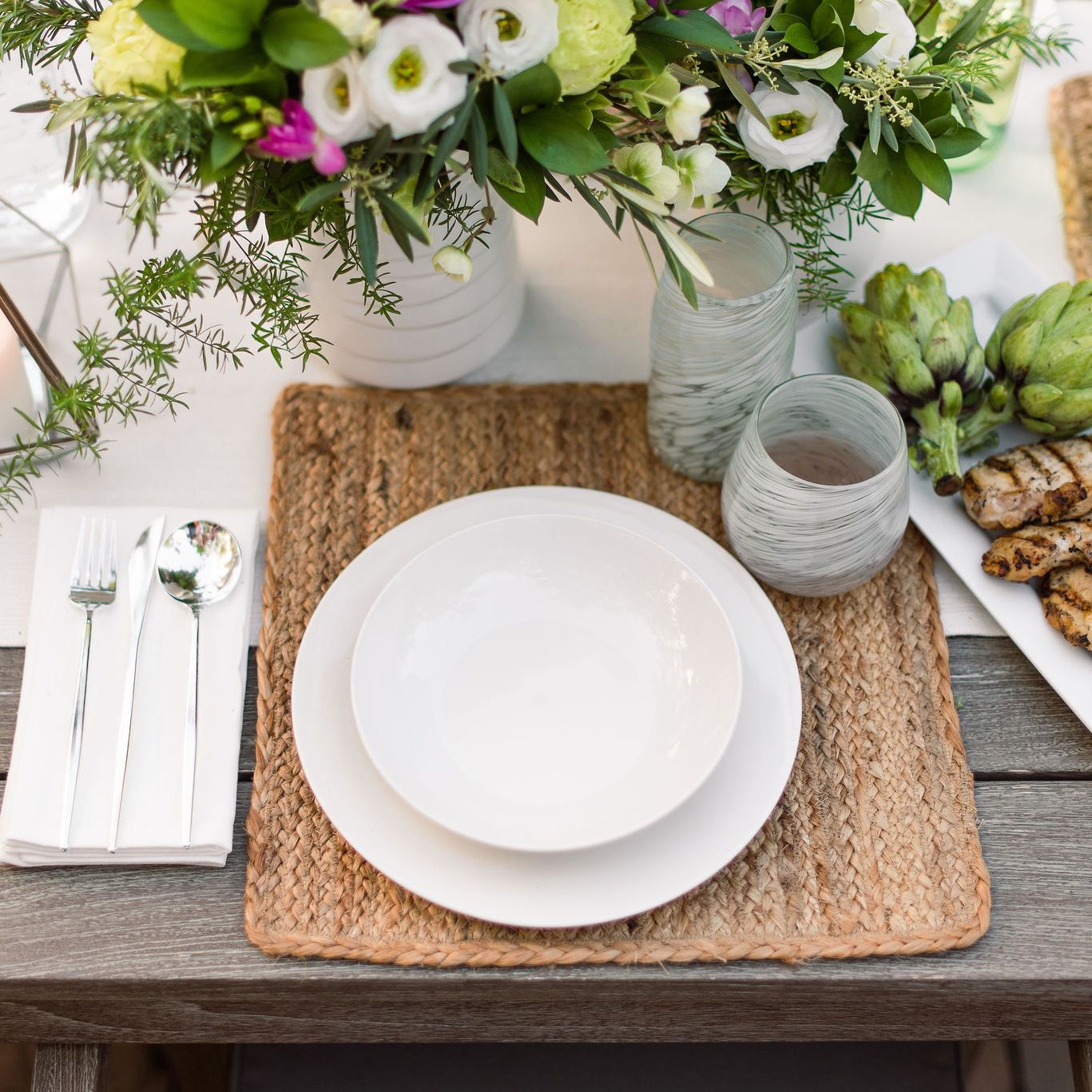 Outdoor dining table setting with grilled chicken.