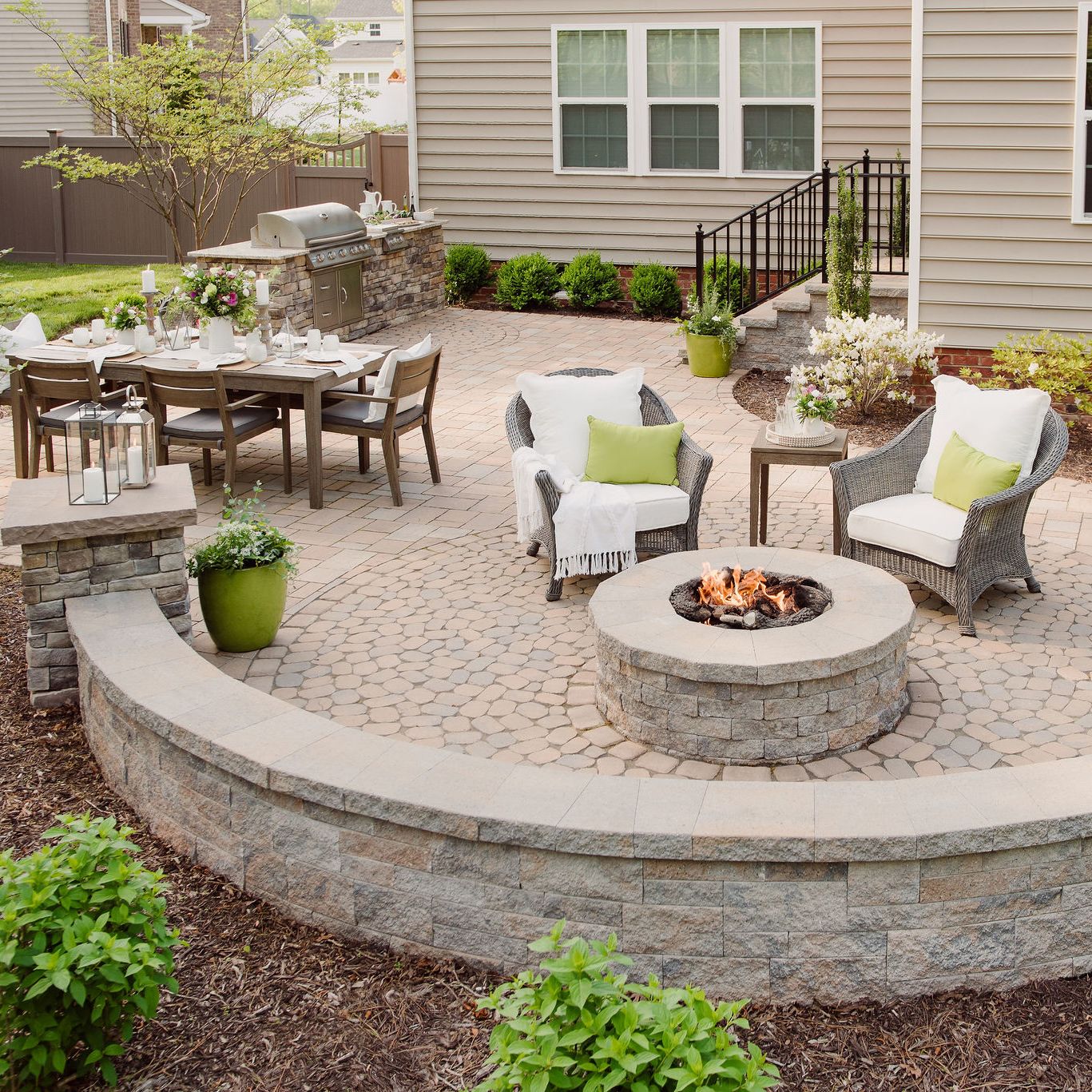 Paver patio with gas fire pit, sitting walls, and grill island.