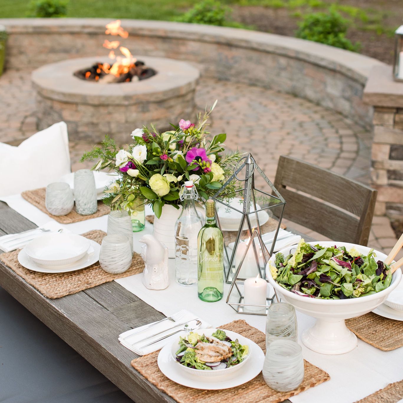 Techo-bloc paver patio  with outdoor dining table and gas fire pit  with sitting wall.