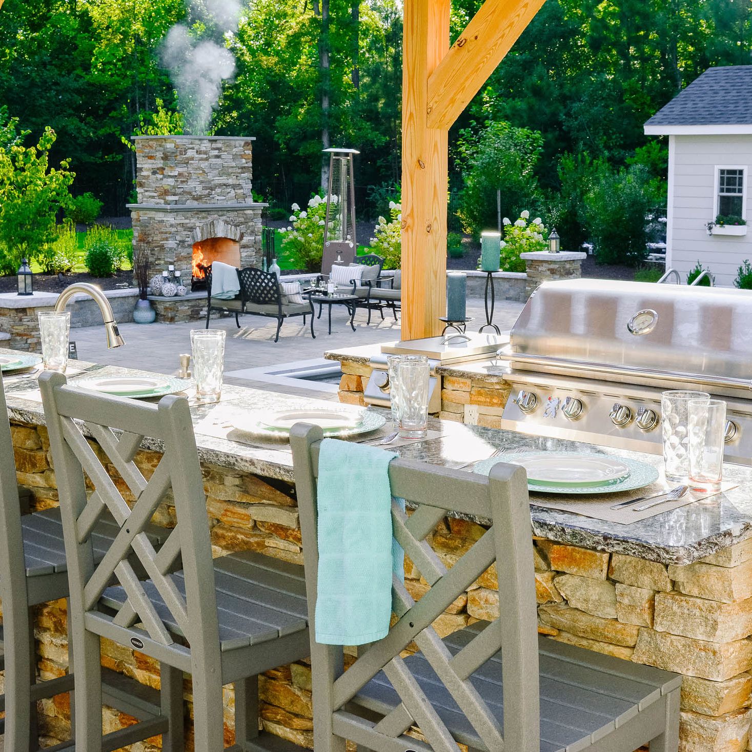 Smoke billowing from outdoor fireplace near outdoor kitchen