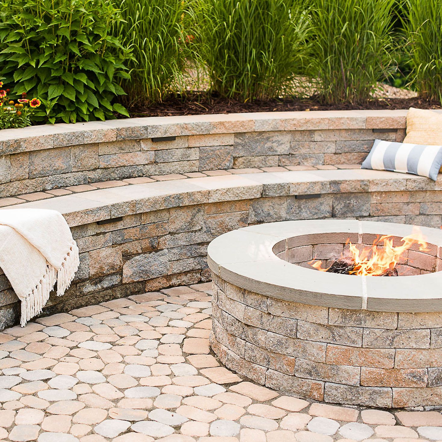 retaining and sitting wall encircles the wood burning fire pit installed into the patio