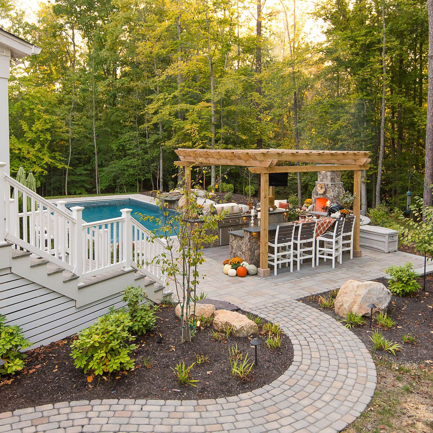 winding paver pathway from the front yard leading into the backyard patio