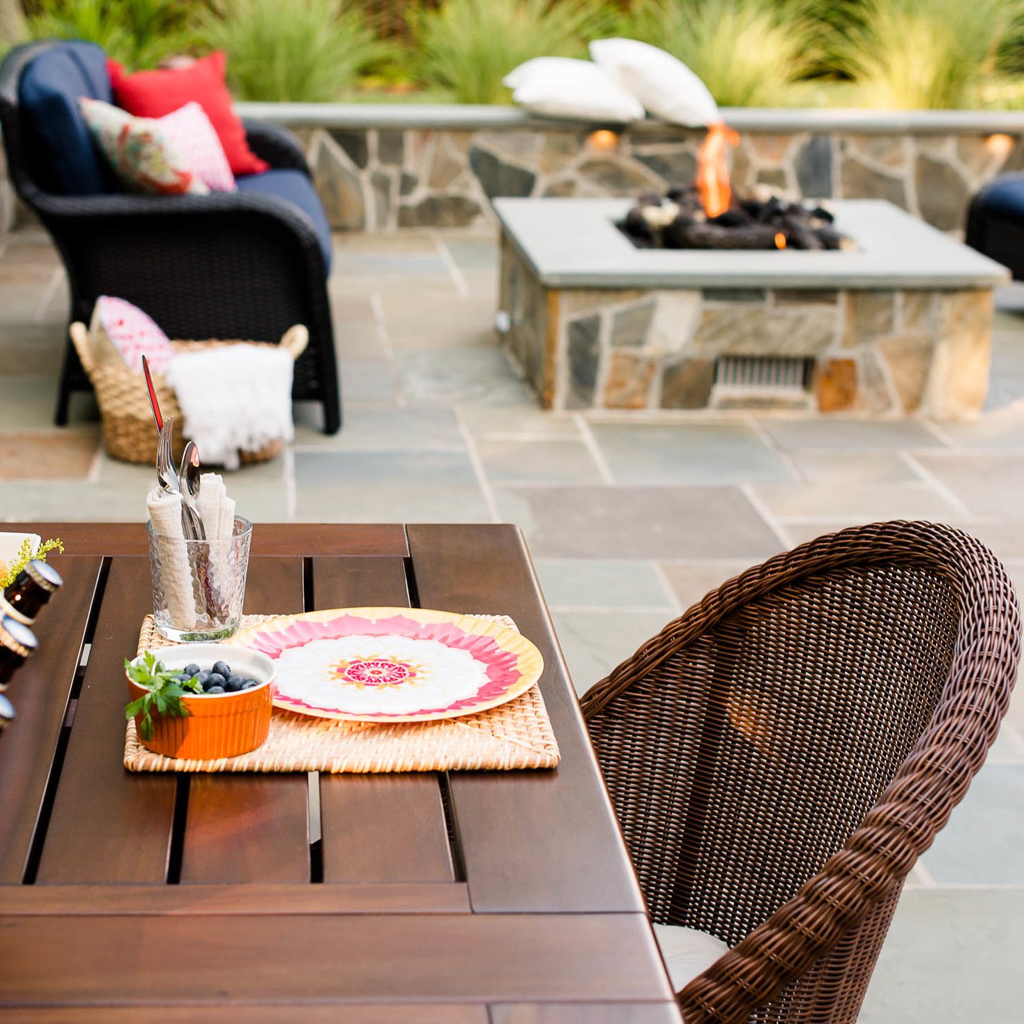 Outdoor table is set and fire is roaring in the gas fire pit in this patio