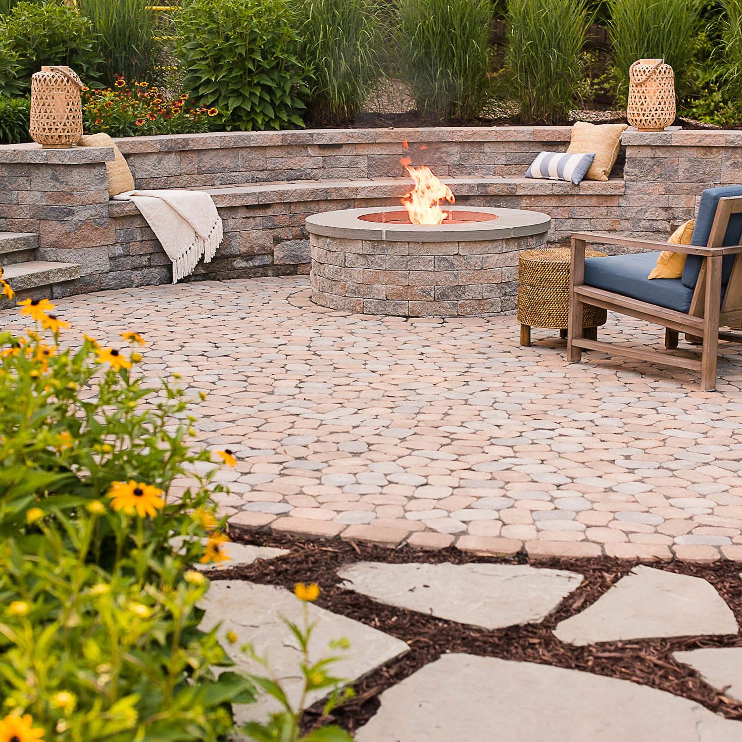 luxury paver patio features stone wood burning fire pit and stone retaining sitting wall
