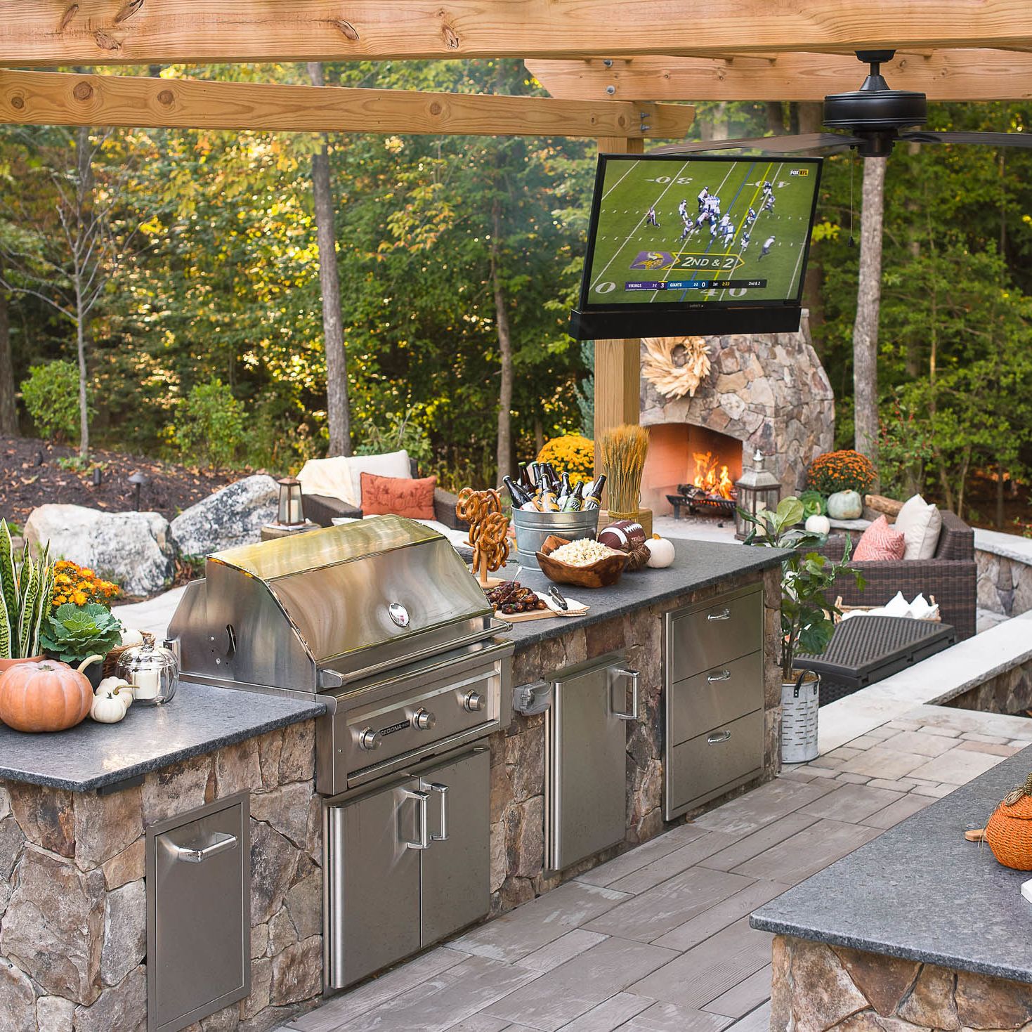 outdoor tv installed over grill island with granite countertops