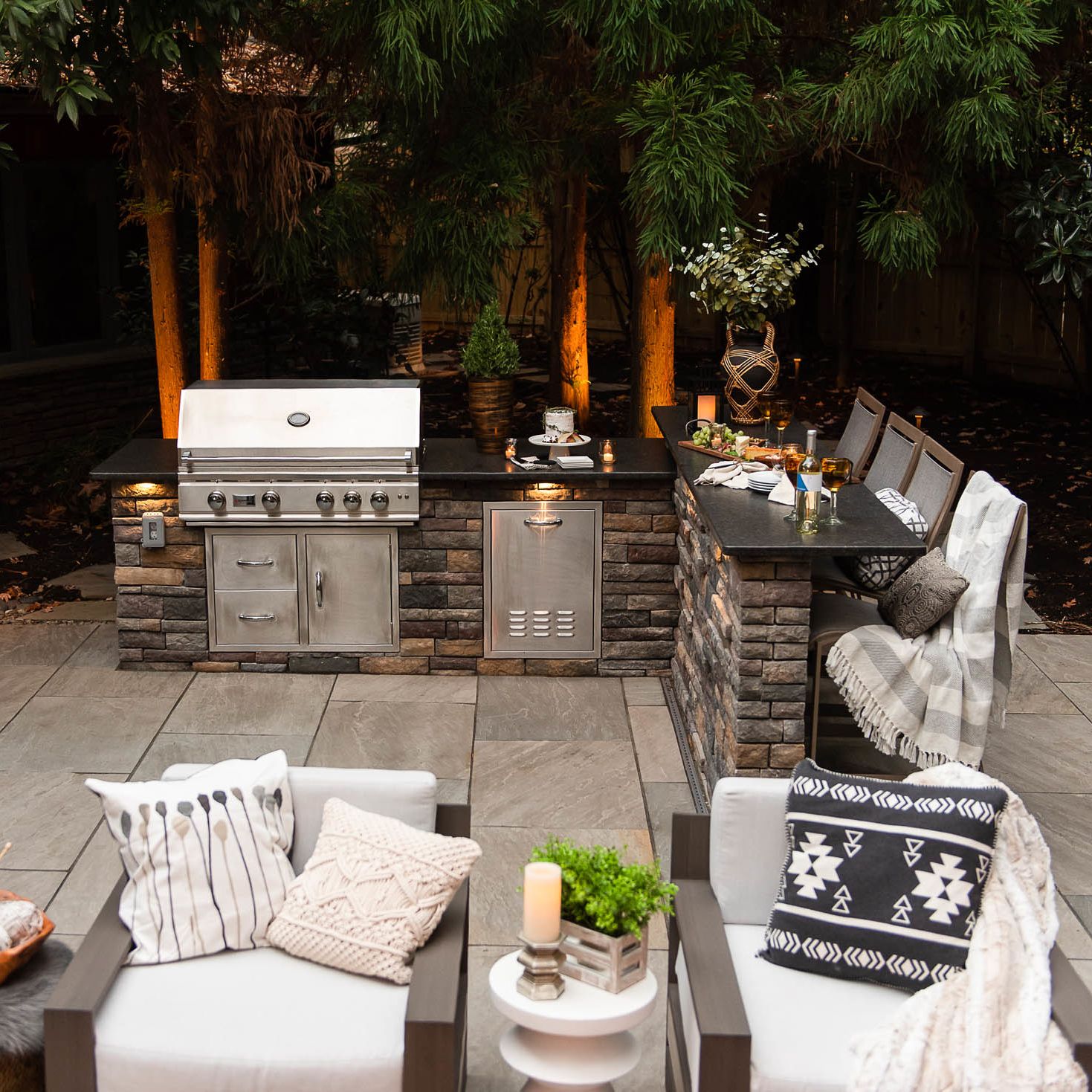 Outdoor grill island with bar seating and granite countertop