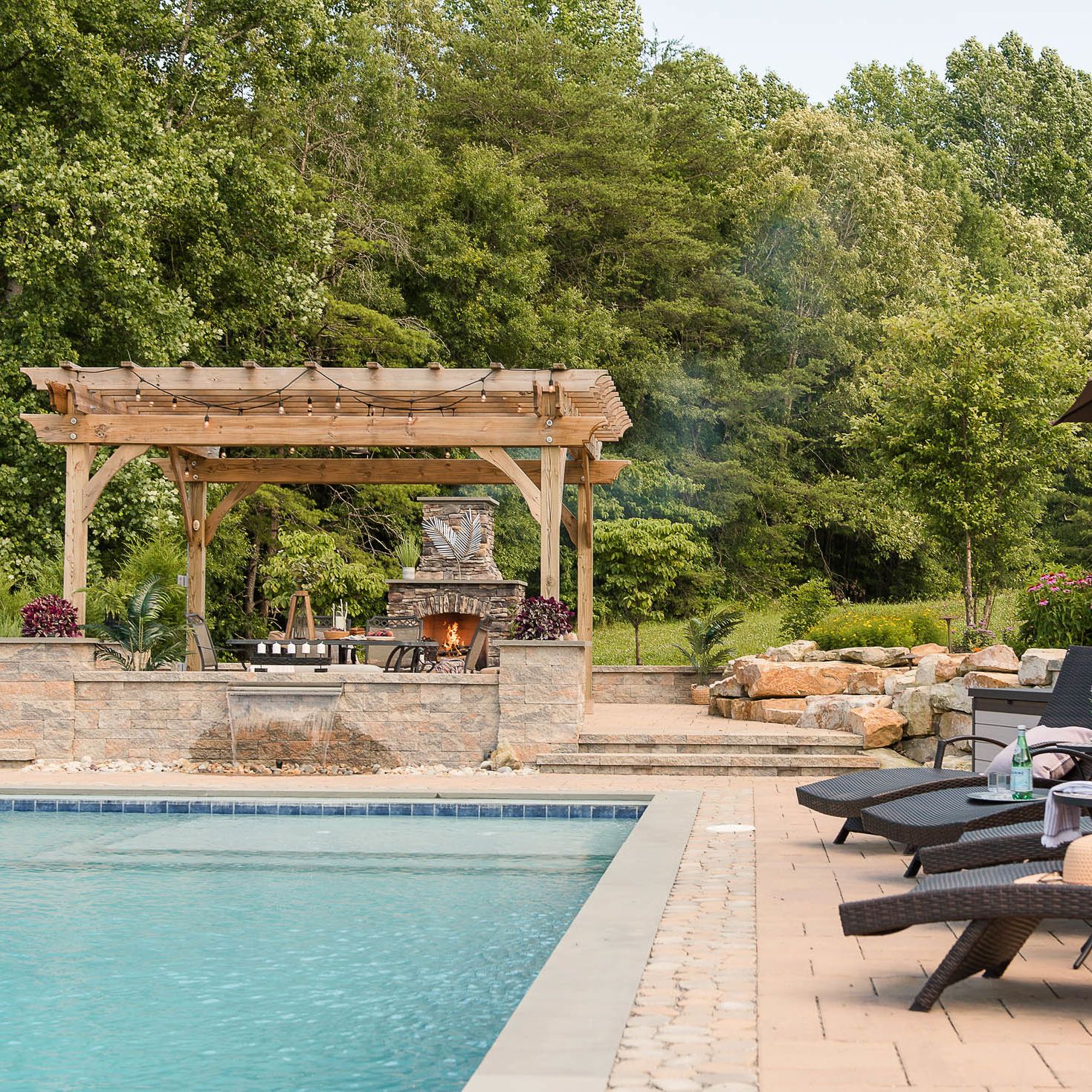 Gunite pool with paver pool decking, fireplace, and pergola
