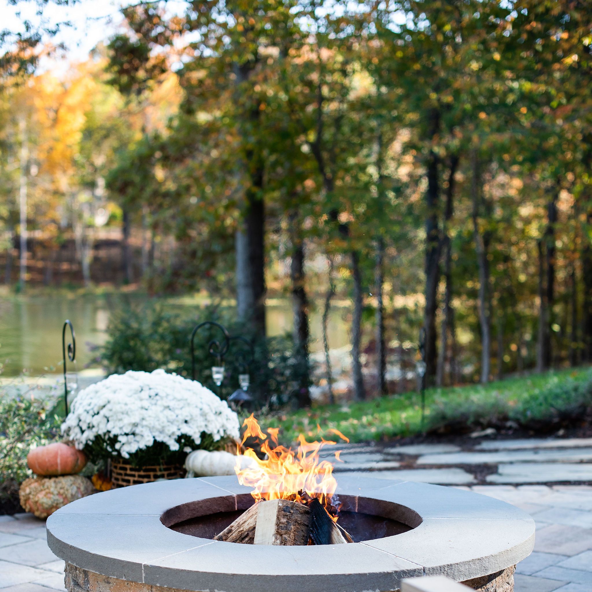 Stone patio overlooking lake with fire pit