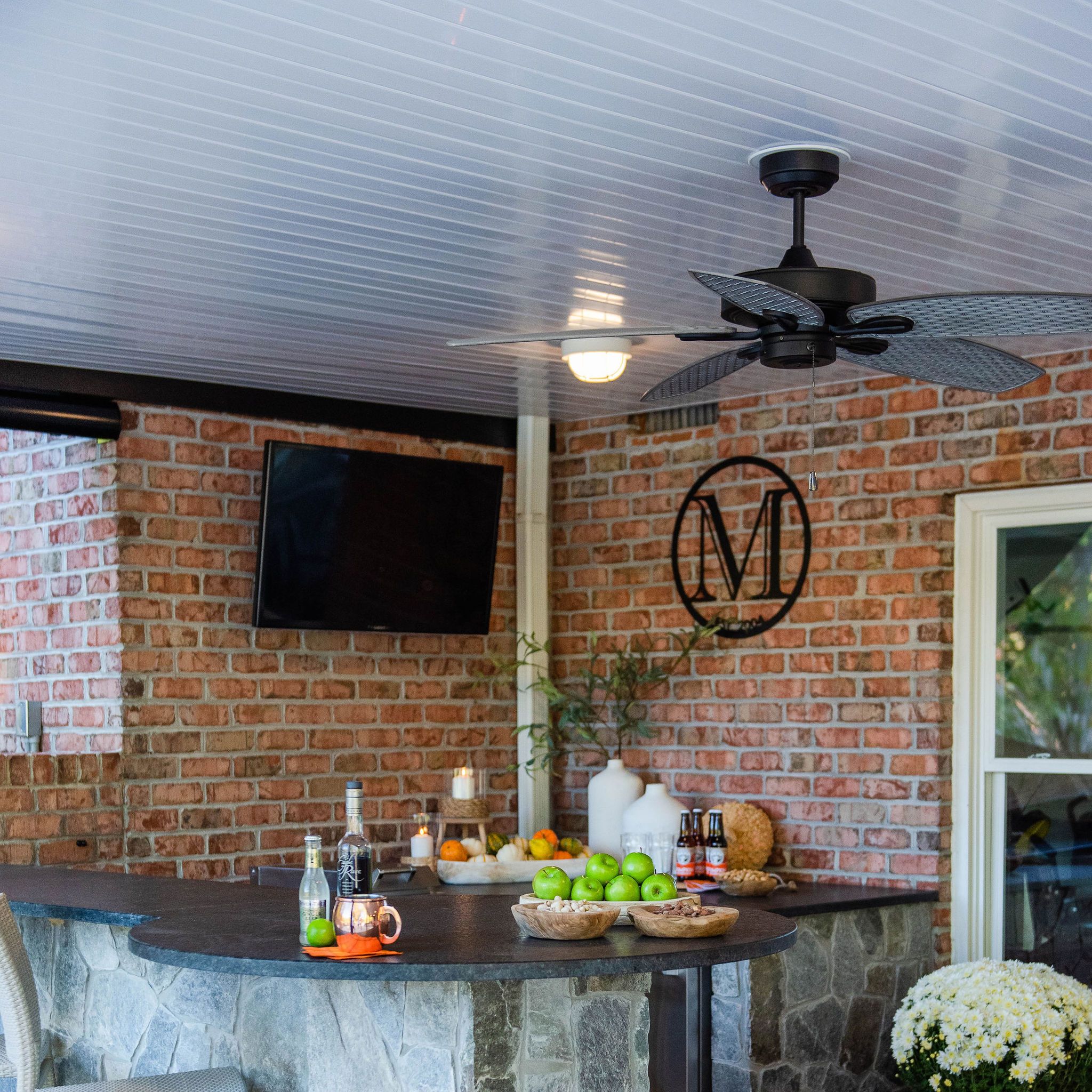 utdoor wet bar under deck with granite counters and TVs