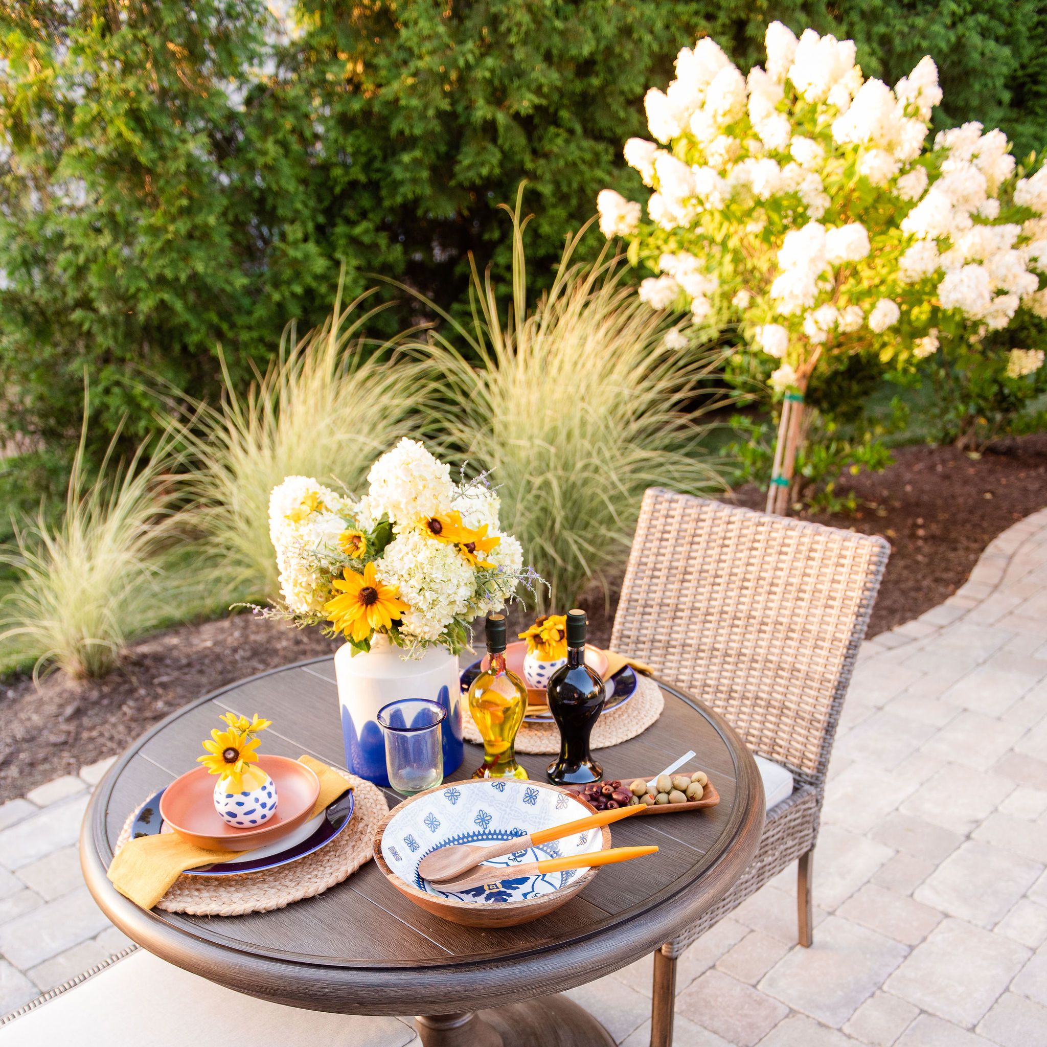 Dining table on a paver patio with landscaping