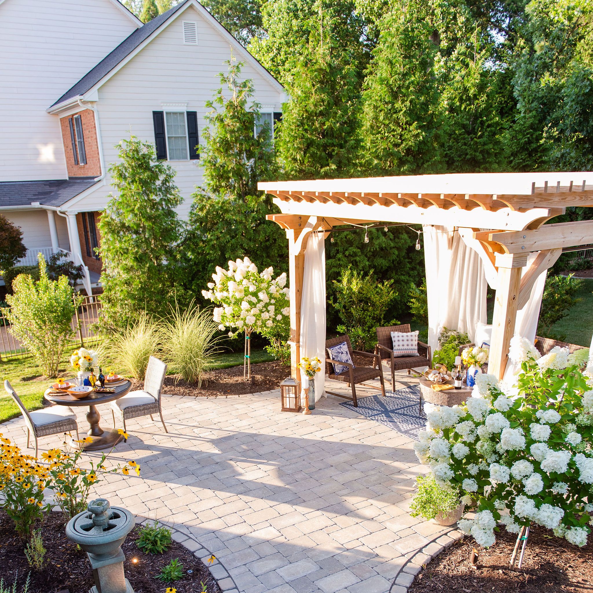 Paver patio with dining area, lounge area, pergola, landscaping and fountain