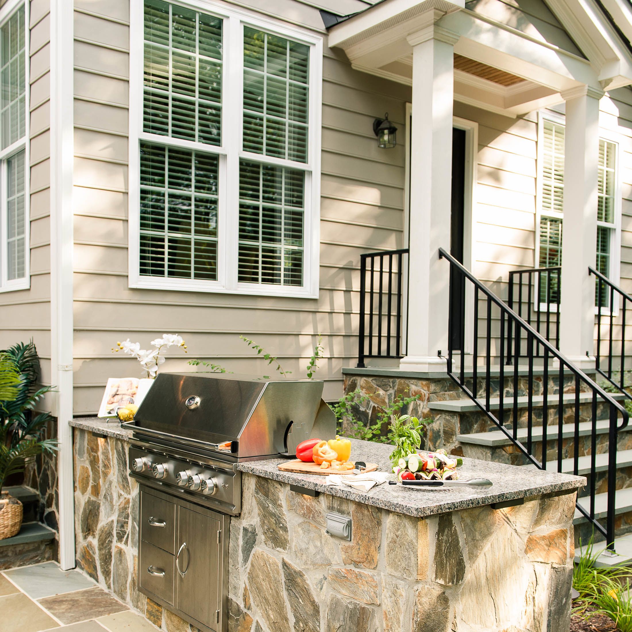 Grill island with large granite countertops and stone veneer