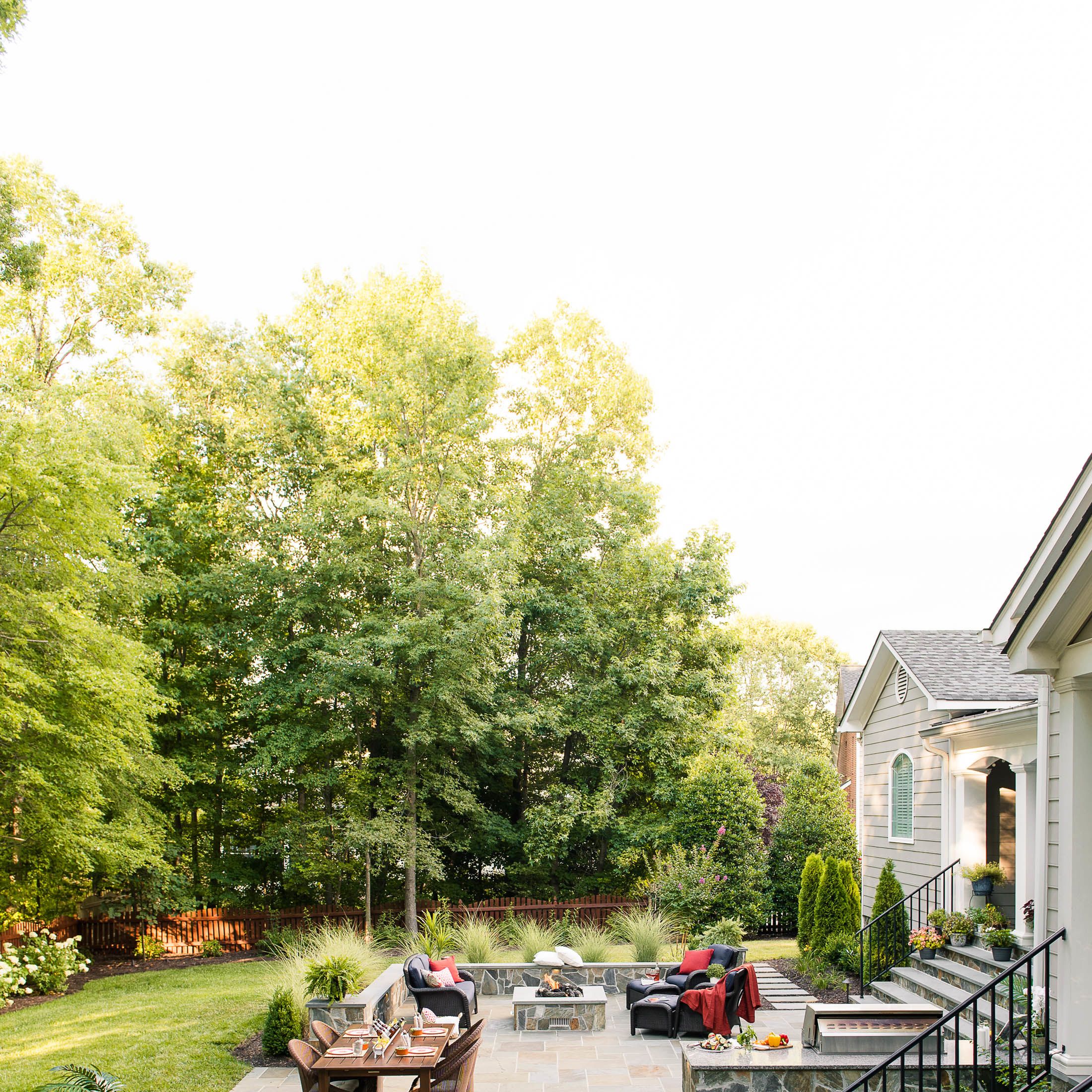 Mortared-bluestone patio landscape features sitting walls, fire pit and a grill island