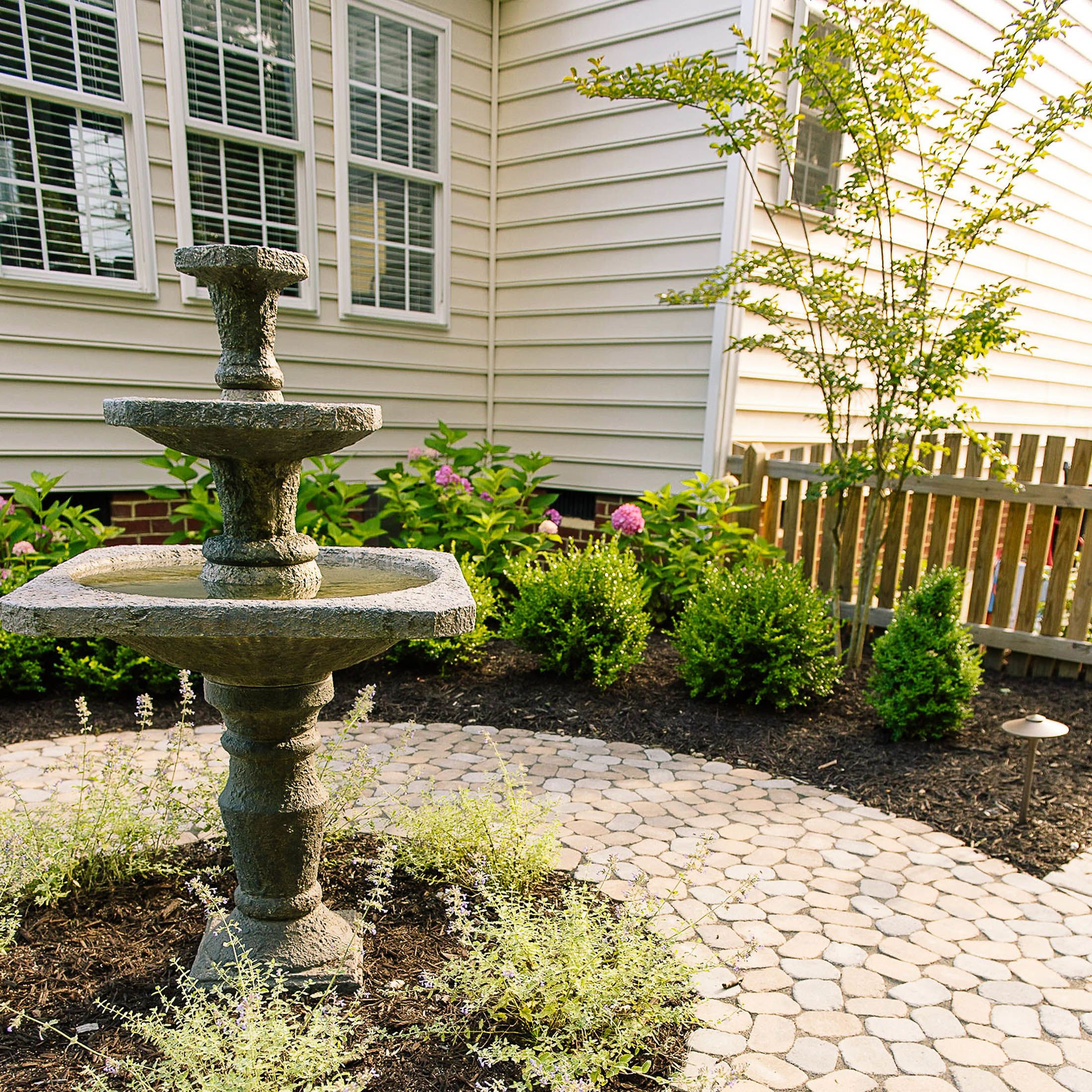 Water fountain surrounded by paver patio