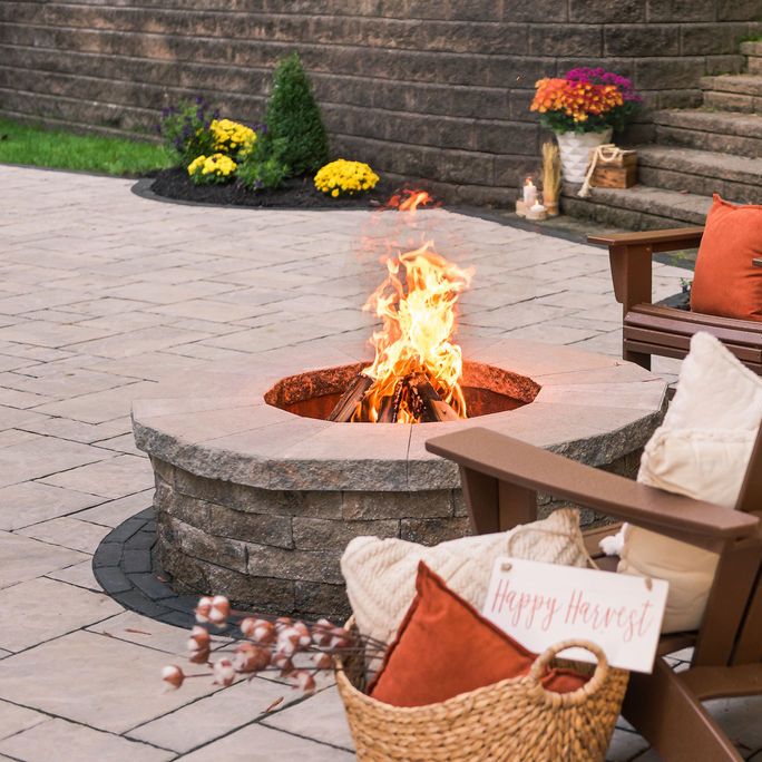 Stone fire pit built into stone paver patio