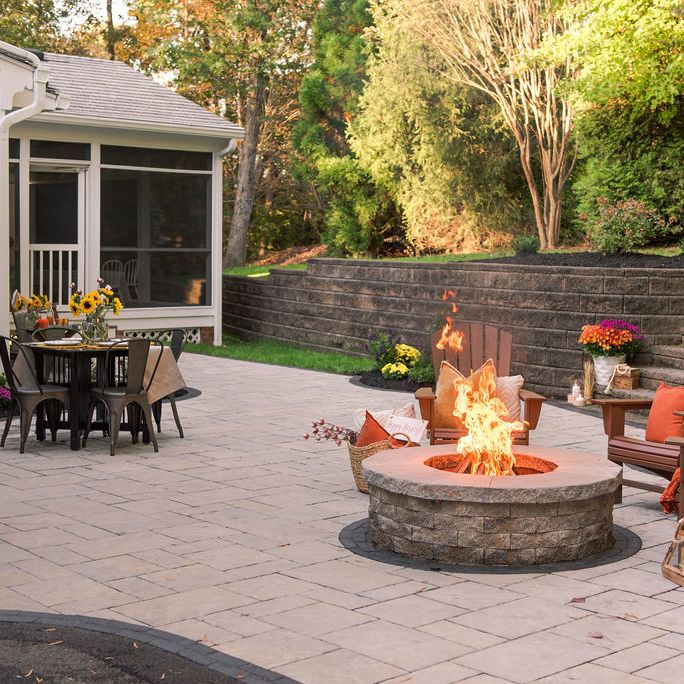 Custom patio built outside screen-in porch featuring a built in fire pit